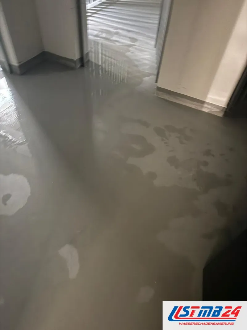 24-Stunden-Notdienst im Neubau: Wasser steht in Flecken und Lachen auf dem grauen Estrich bis in die Nebenräume
