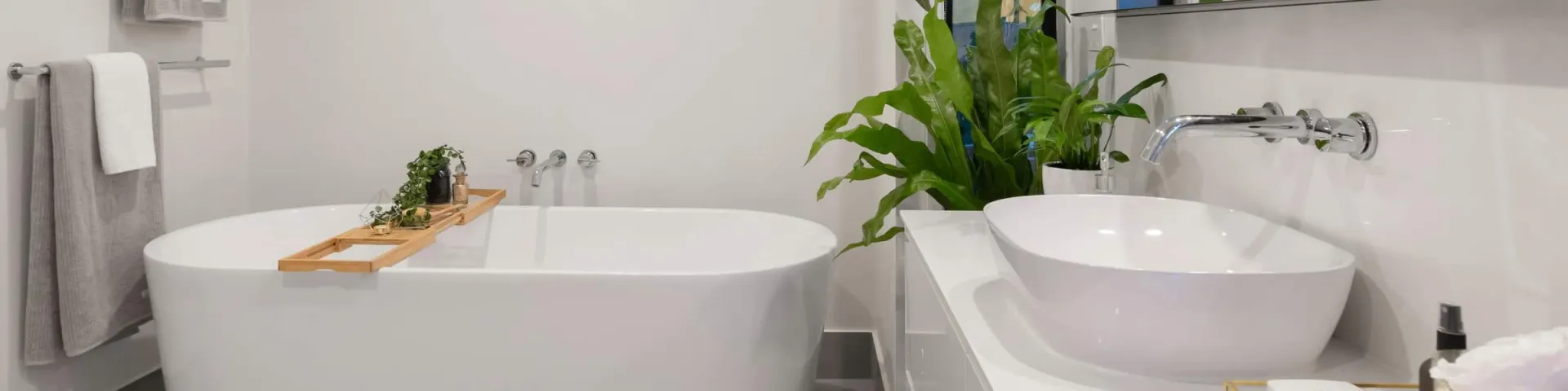 Badsanierung: helles Bad mit freistehender Badewanne, Aufsatzwaschbecken und Wandarmaturen in Chrom