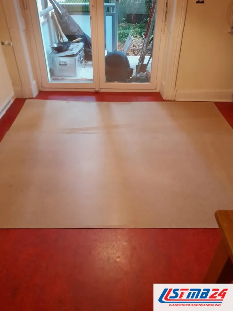Bodenbelagsarbeiten: Schutzpappe auf rotem Linoleum vor der Terrassentür
