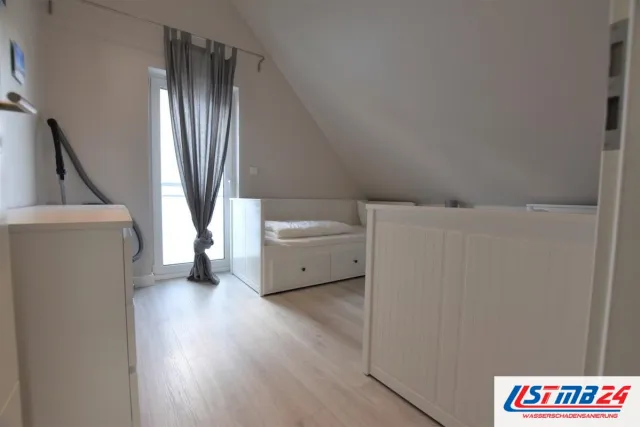 Bodenbelagsarbeiten: neuer Boden in heller Holzoptik im Dachzimmer, verlegt bis zur bodentiefen Fenstertür unter der Dachschräge