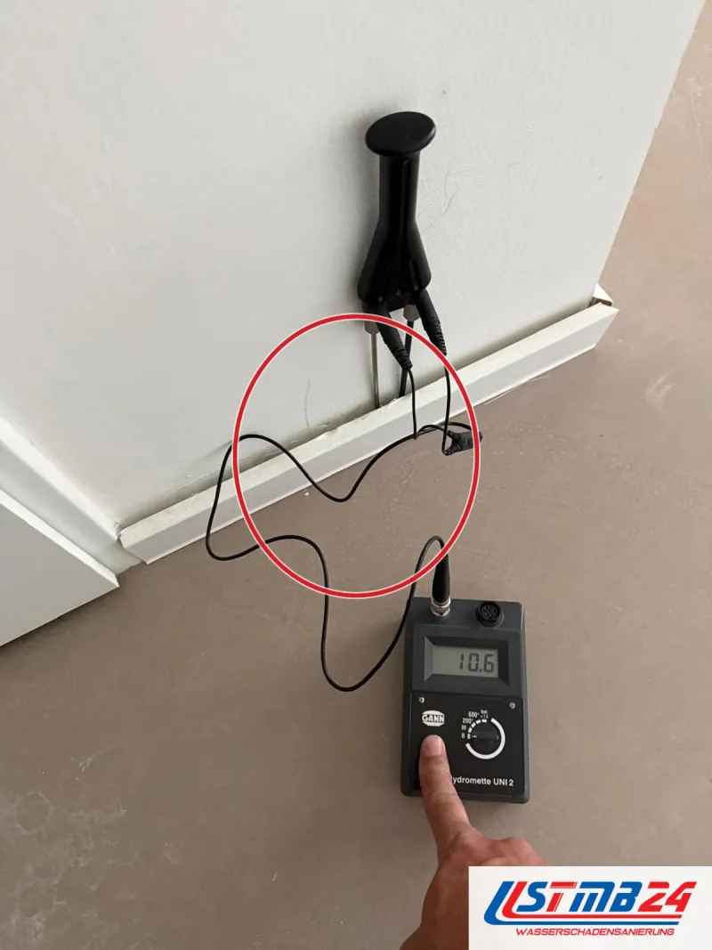 Messgerät, Elektrode an der Wand über der Sockelleiste, ein roter Kreis markiert die Stelle