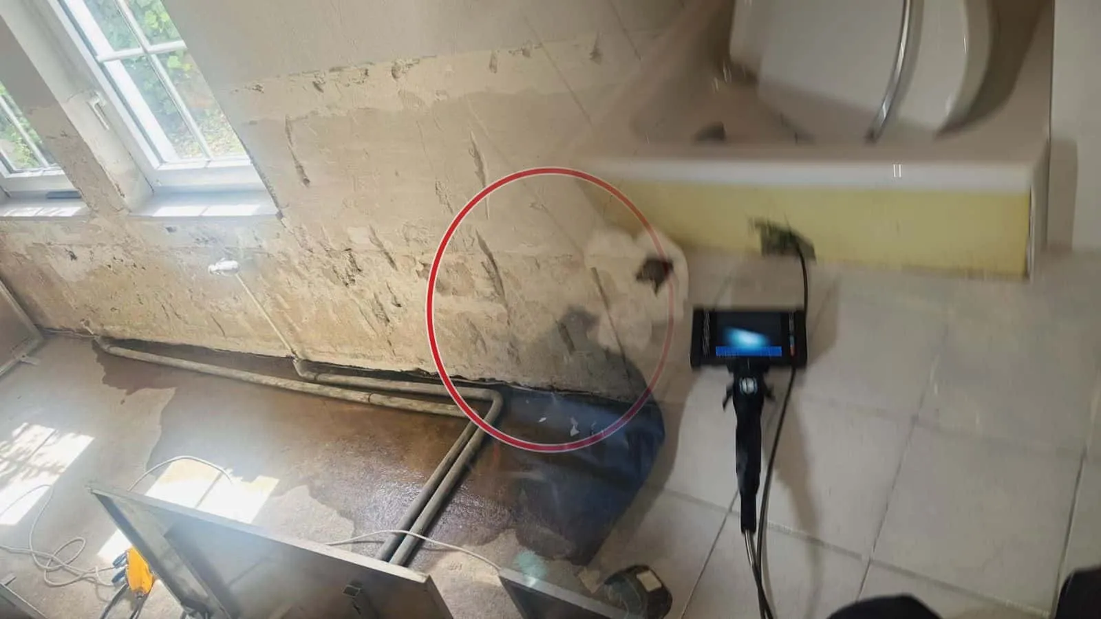 Endoskop mit Monitor vor einer Badewanne, daneben die blaue Gerätetasche
