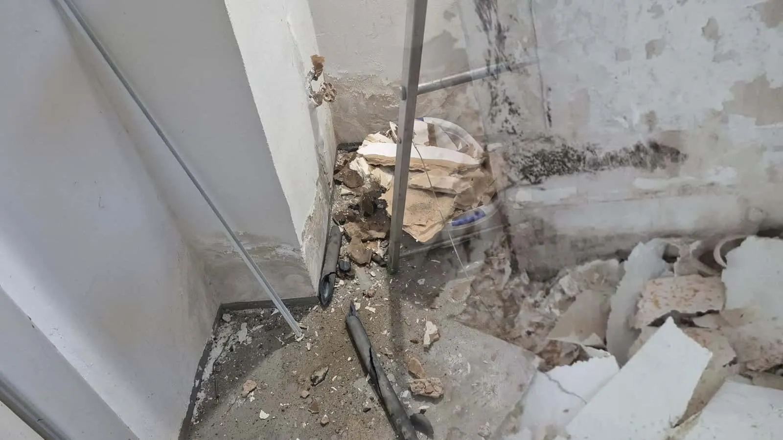 Raumecke mit abgeplatztem Putz, Schimmel und Schutt