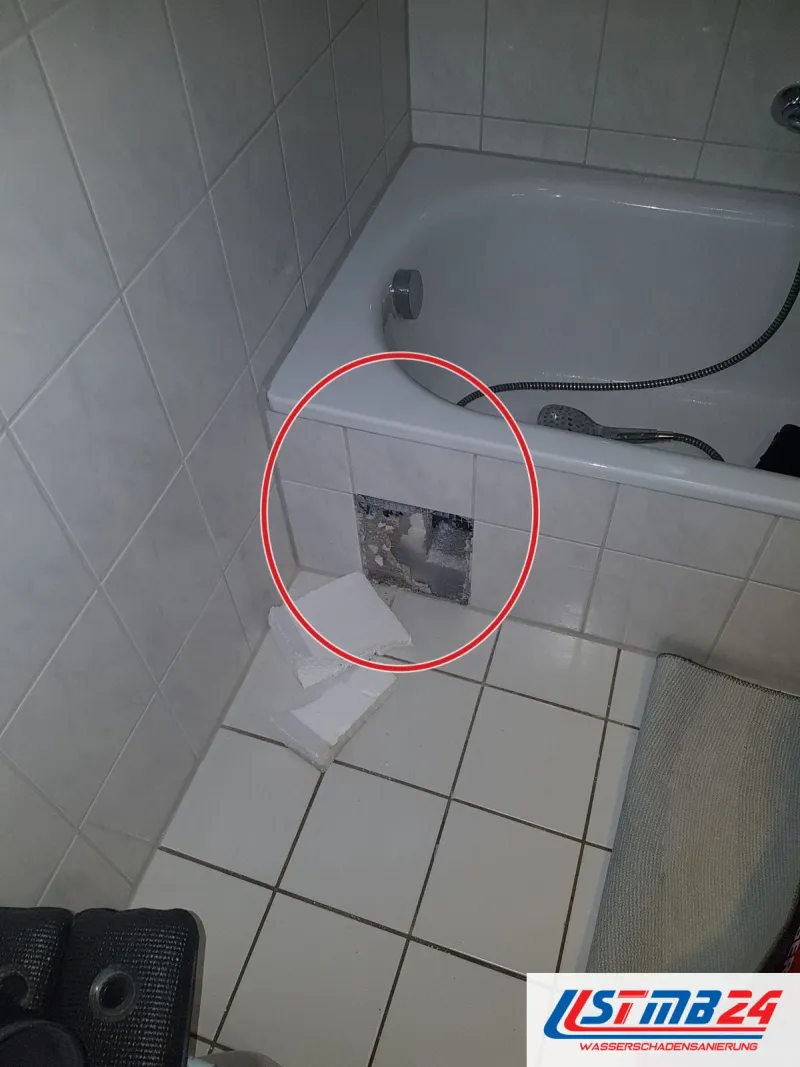 Badewanne mit geöffneter Fliese in der Schürze, ein roter Kreis markiert die Stelle