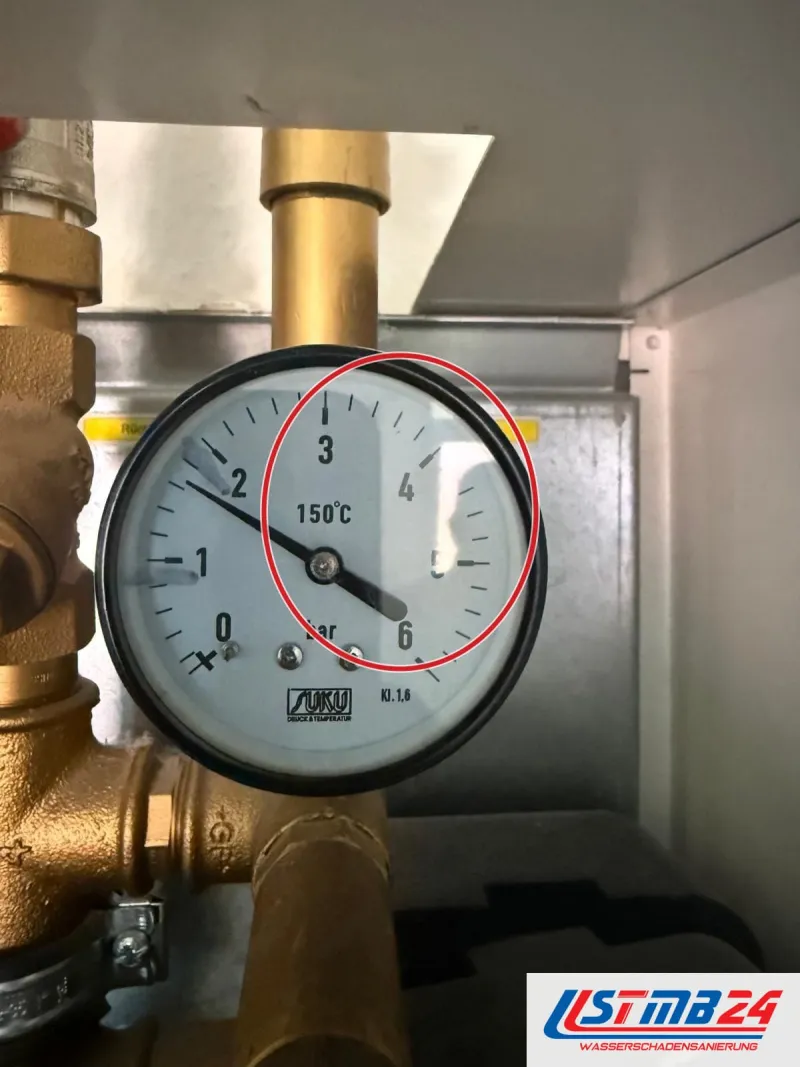 Manometer am Messingverteiler einer Heizungsanlage, ein roter Kreis markiert die Stelle