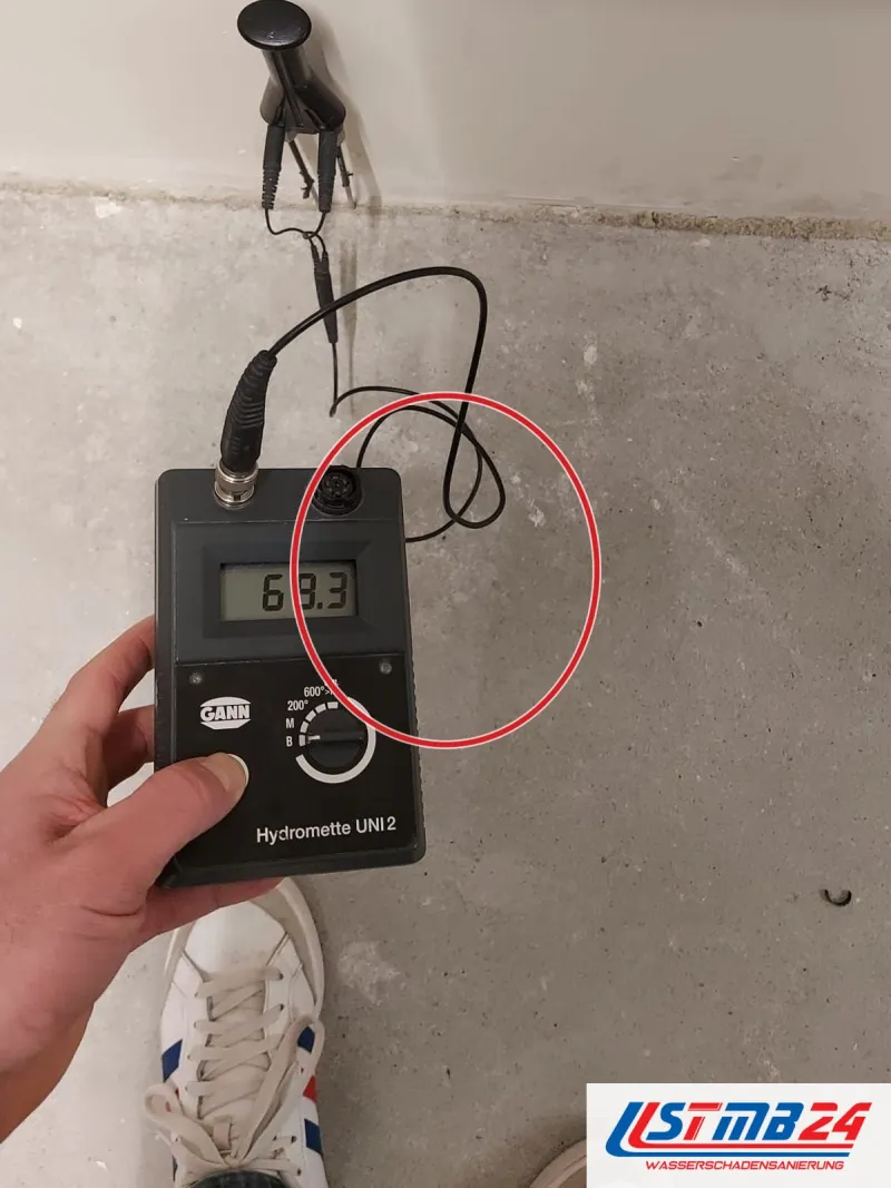 Messgerät mit Anzeige 68,3, Elektrode an der Wand über dem Estrich, ein roter Kreis markiert die Stelle