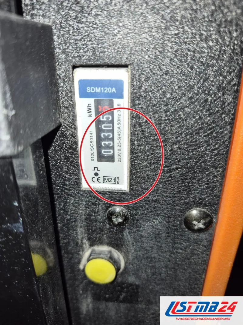 Zwischenzähler SDM120A am Gehäuse eines Trocknungsgeräts zeigt den Verbrauch in Kilowattstunden, ein roter Kreis markiert die Stelle