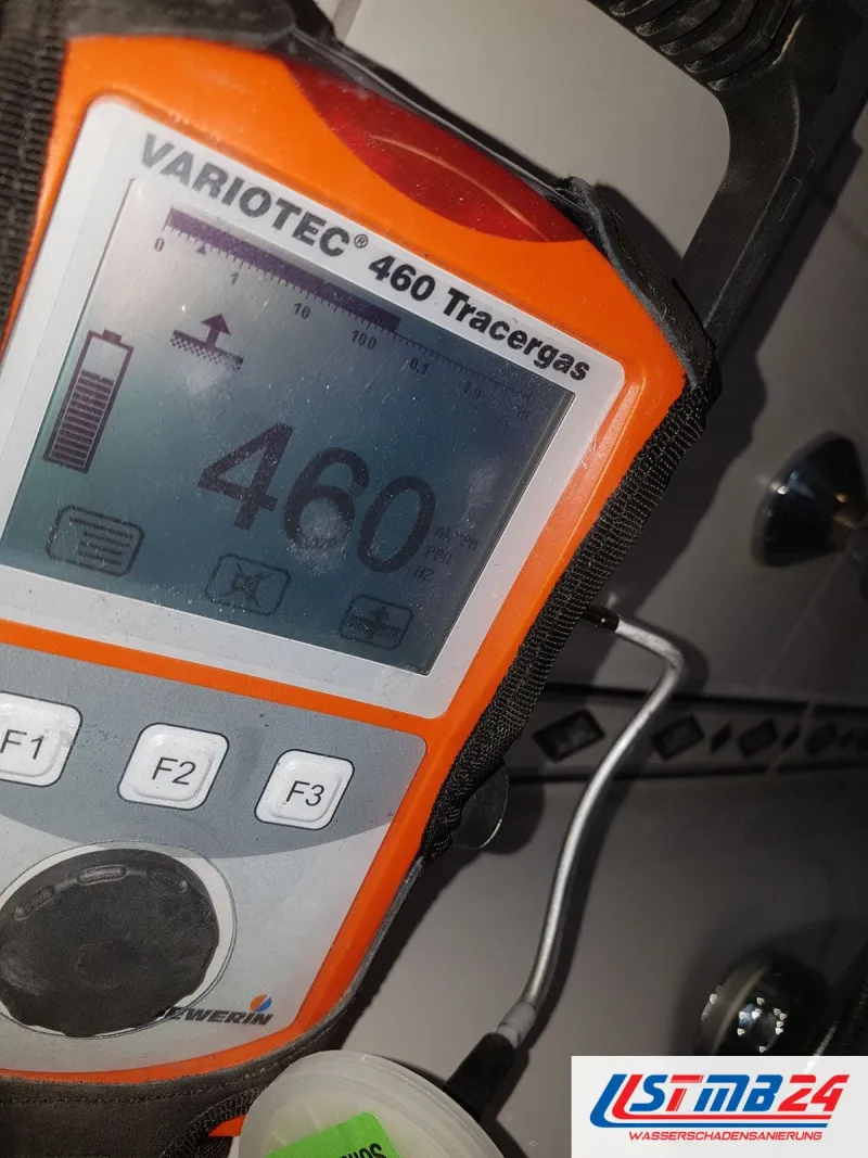 Oranges Tracergas-Messgerät zeigt 460 ppm Wasserstoff an, die gebogene Sonde liegt an der Wand neben den Armaturen