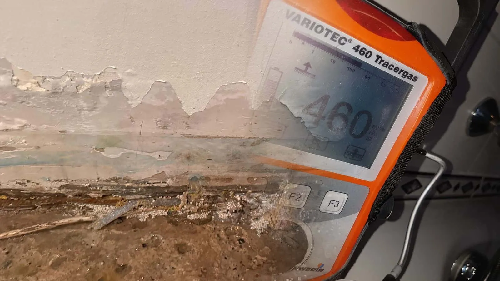 Tracergas-Messgerät mit orangem Gehäuse und großer Anzeige in der Hand