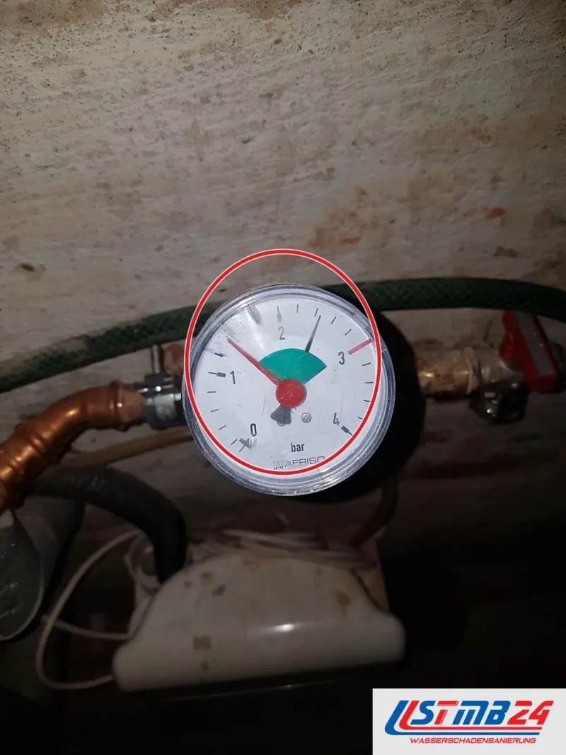 Manometer an der Heizungsleitung, Zeiger im grünen Bereich, ein roter Kreis markiert die Stelle