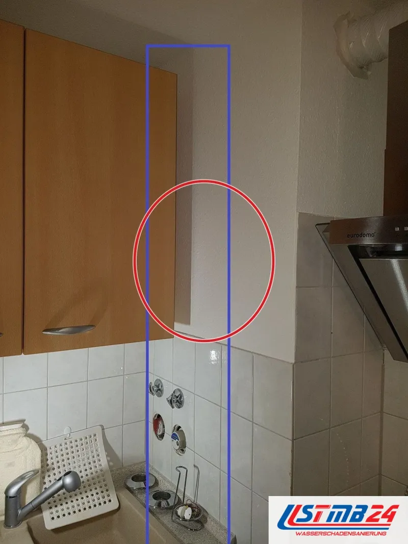 Hängeschrank in Buche, daneben markiert ein blauer Rahmen die Wandanschlüsse über der Spüle, ein roter Kreis markiert die Stelle