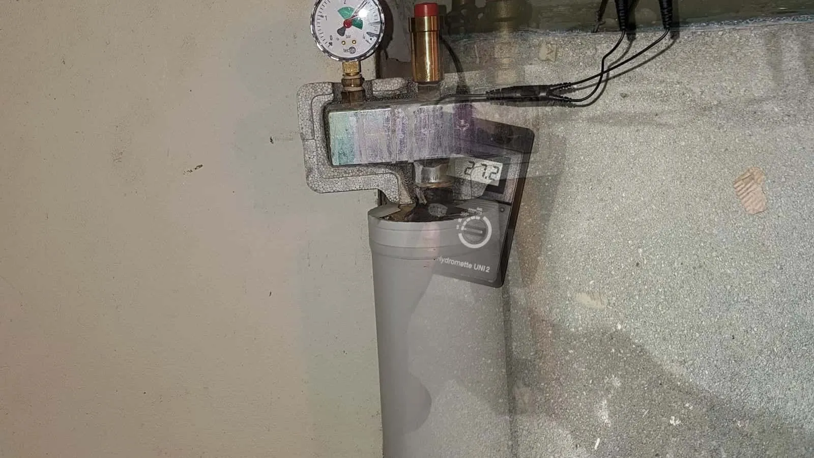 Messgerät mit Elektroden am Estrich vor einer grünen Wand