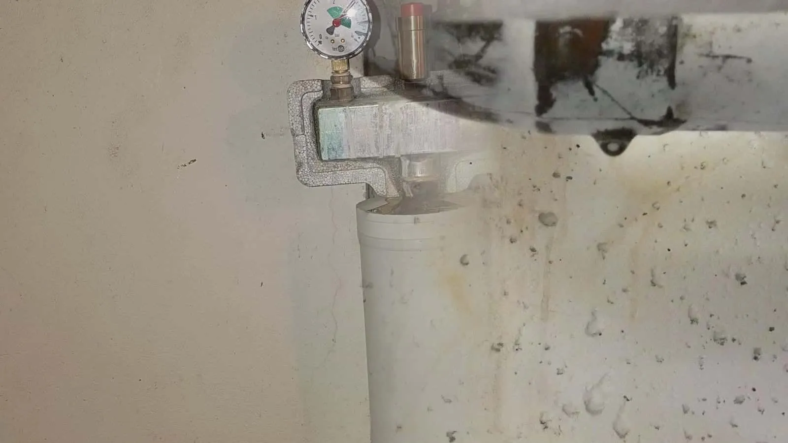 Rohre unter einer Kellerdecke, an der Leitung hängt ein Tropfen