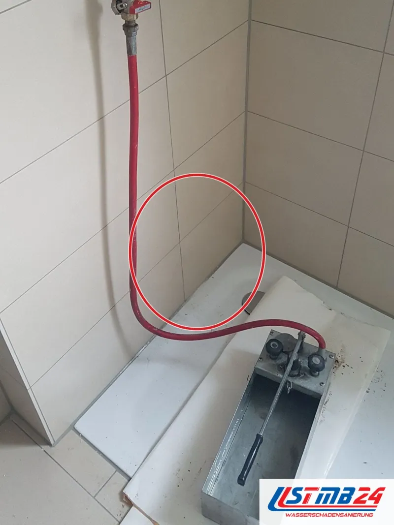 Manometer an einer Wandleitung, roter Schlauch, ein roter Kreis markiert die Stelle