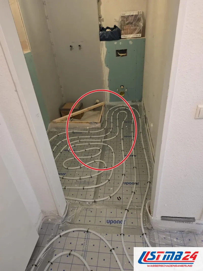 Fußbodenheizung in Schlaufen vom Flur bis ins Bad verlegt, im Bad die Vorwand für das WC, ein roter Kreis markiert die Stelle