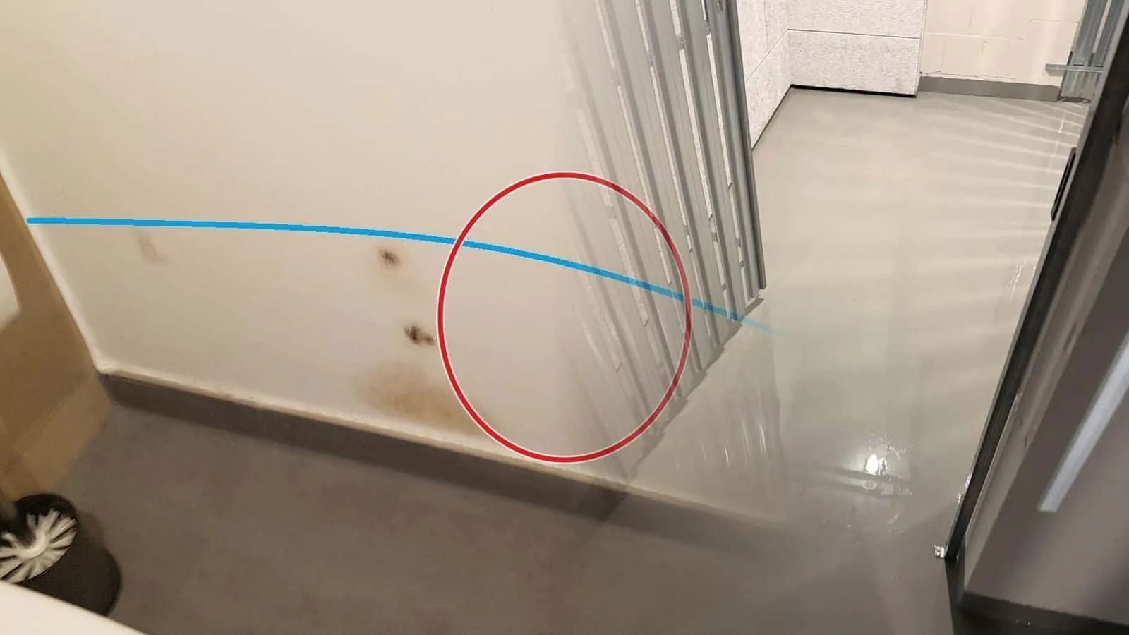 Nass glänzender Estrich zwischen Ständerwänden bis an eine Kalksandsteinwand