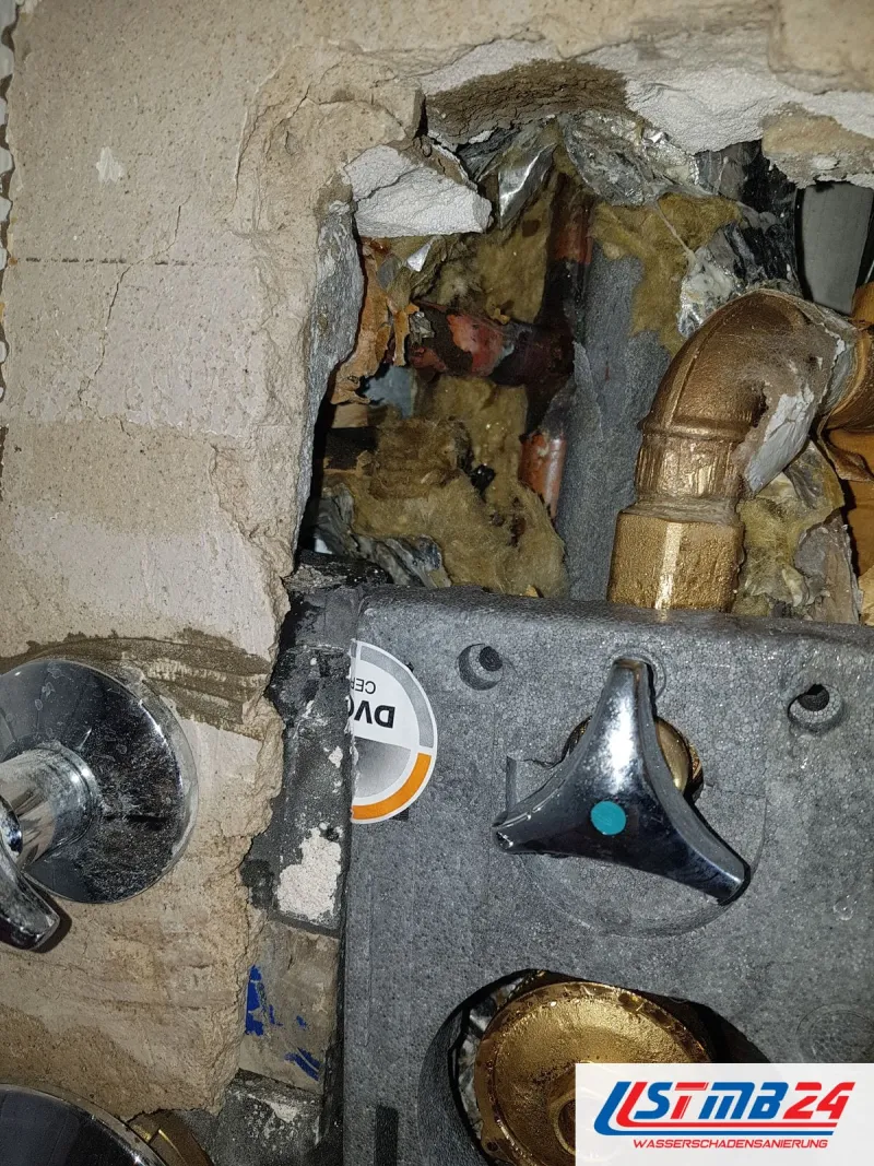 Geöffnete Vorwand mit Messinganschlüssen zwischen Dämmung und Mauerwerk