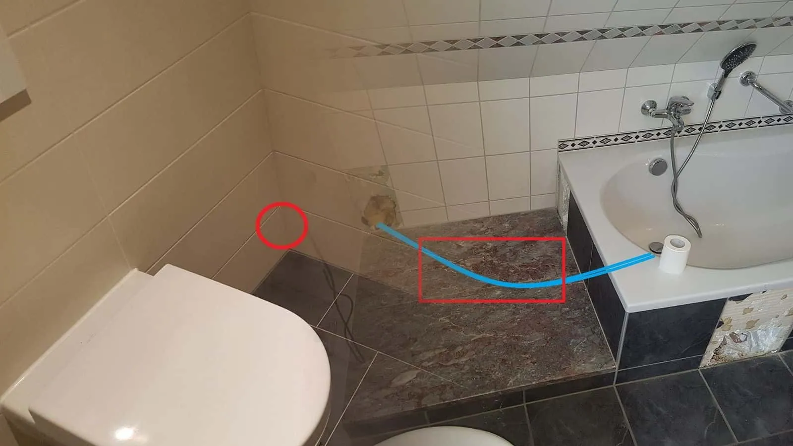 Bad mit Wanne und Marmorstufe, eine blaue Linie zeigt den Verlauf der Leitung unter der Stufe, ein rotes Rechteck die Leckstelle