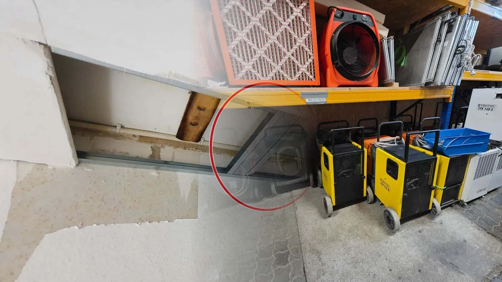 Kondenstrockner in Gelb und Weiß im Lagerregal, darüber ein Ventilator und ein Luftreiniger