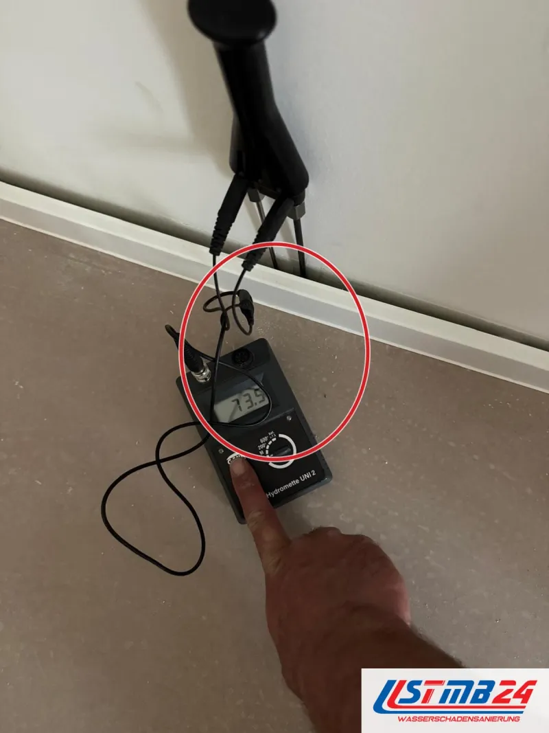 Messgerät, Elektrode an der Wand über der Sockelleiste, nah, ein roter Kreis markiert die Stelle