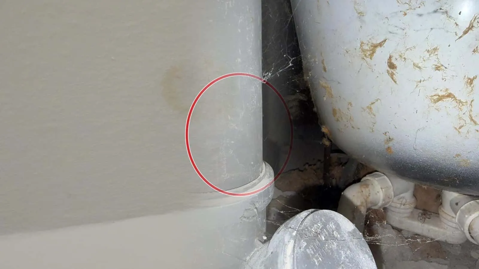 Abflussrohr neben einem Warmwasserspeicher mit Rostflecken