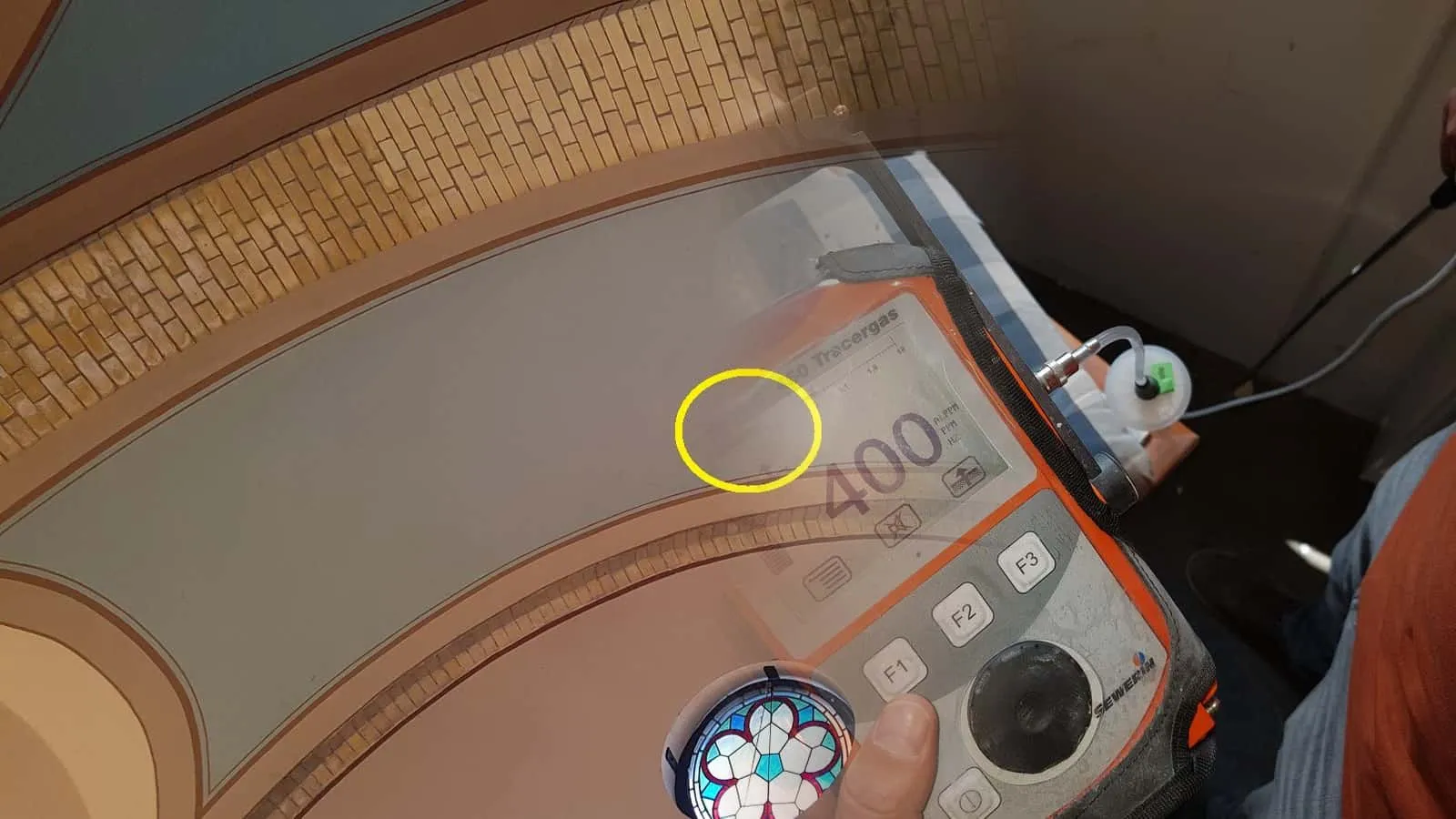 Messgerät für Tracergas mit der Anzeige 400, daneben der Schlauch der Sonde