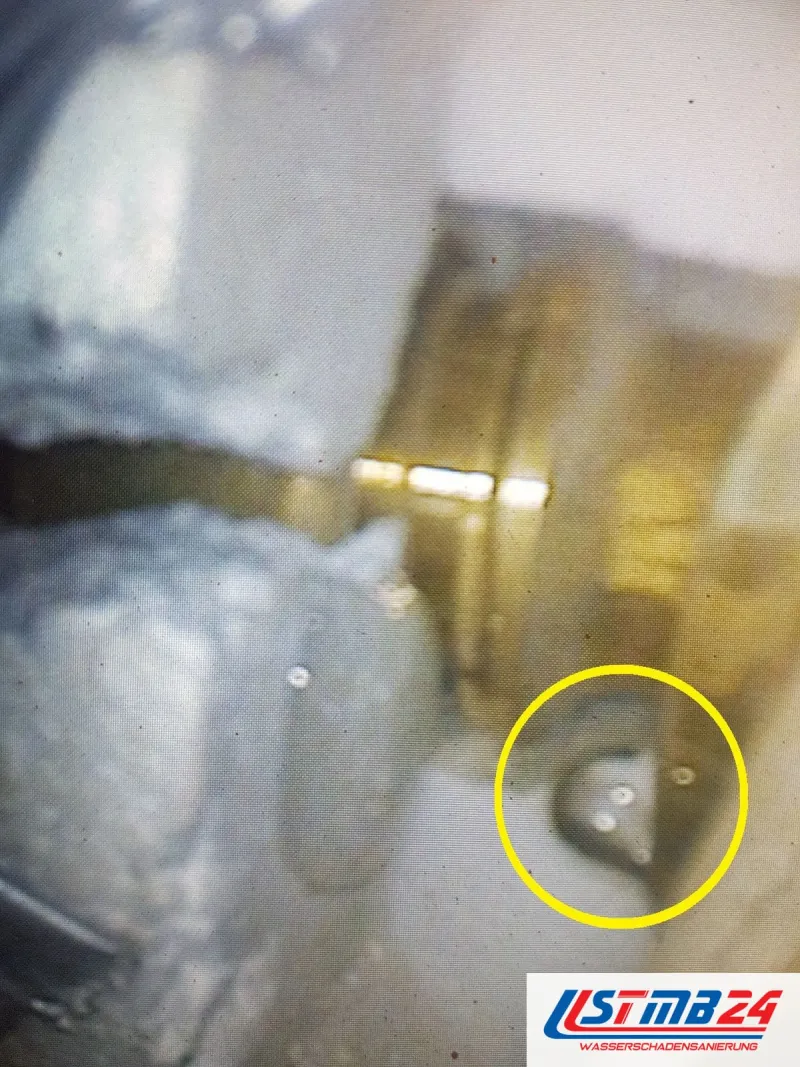 Bild aus dem Endoskop: Messingverbindung in der Wand, gelb umkreist ein Wassertropfen, der an der Mutter austritt