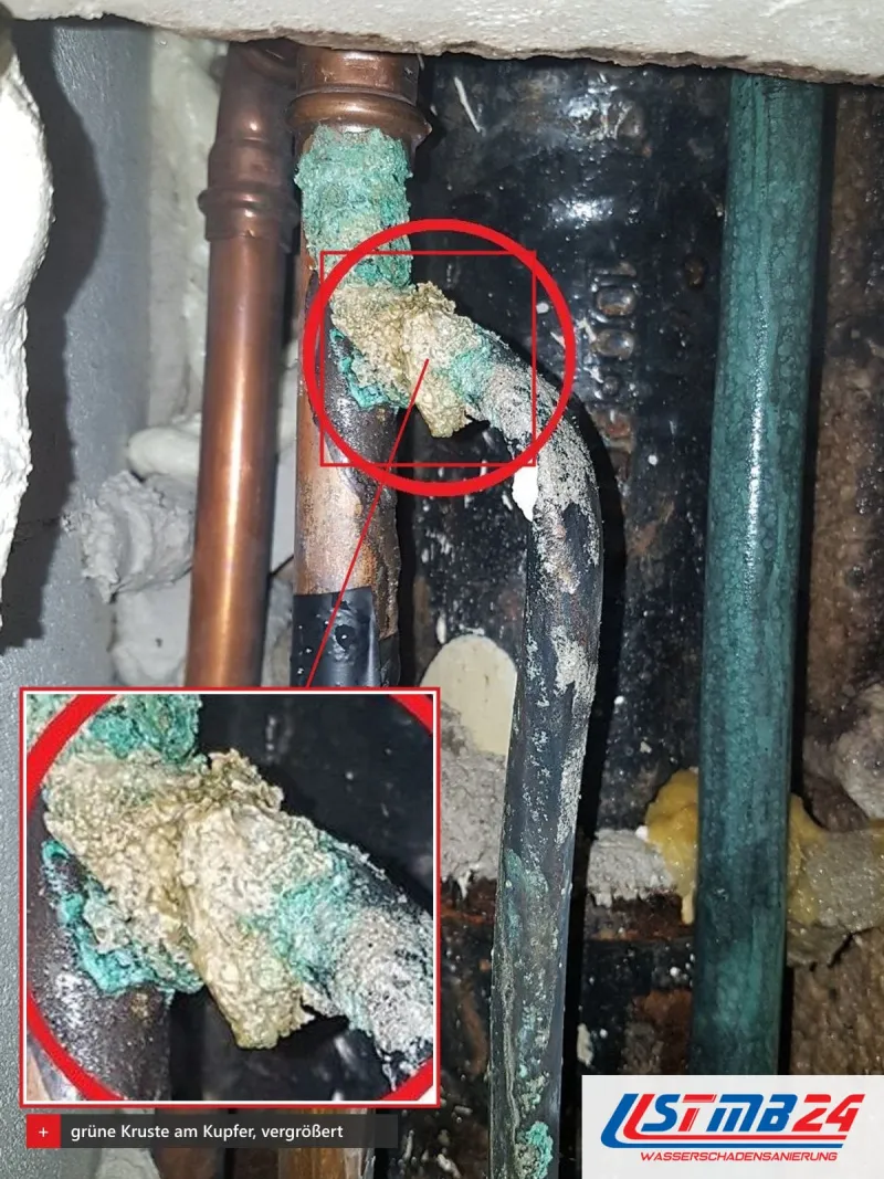 Kupfer- und Stahlrohre im offenen Schacht, die grün verkrustete Verbindung ist rot markiert und vergrößert