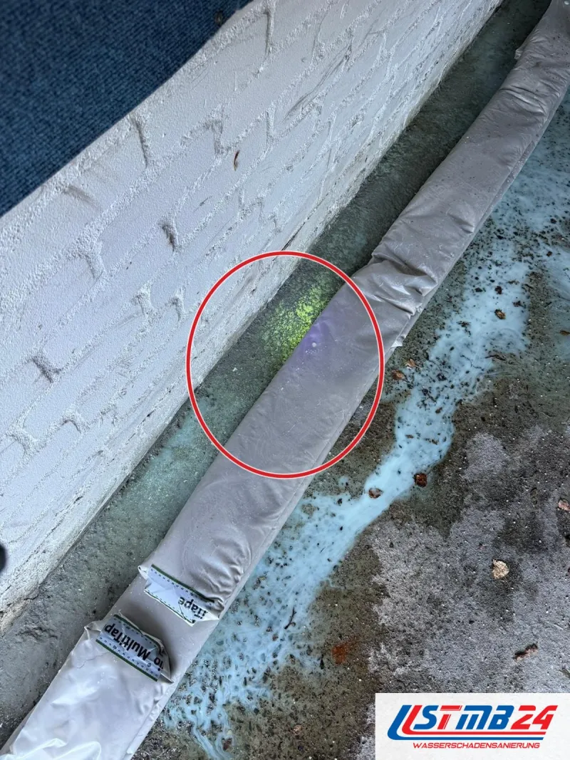 Lüftungsschläuche an der Kellerwand, nah, ein roter Kreis markiert die Stelle