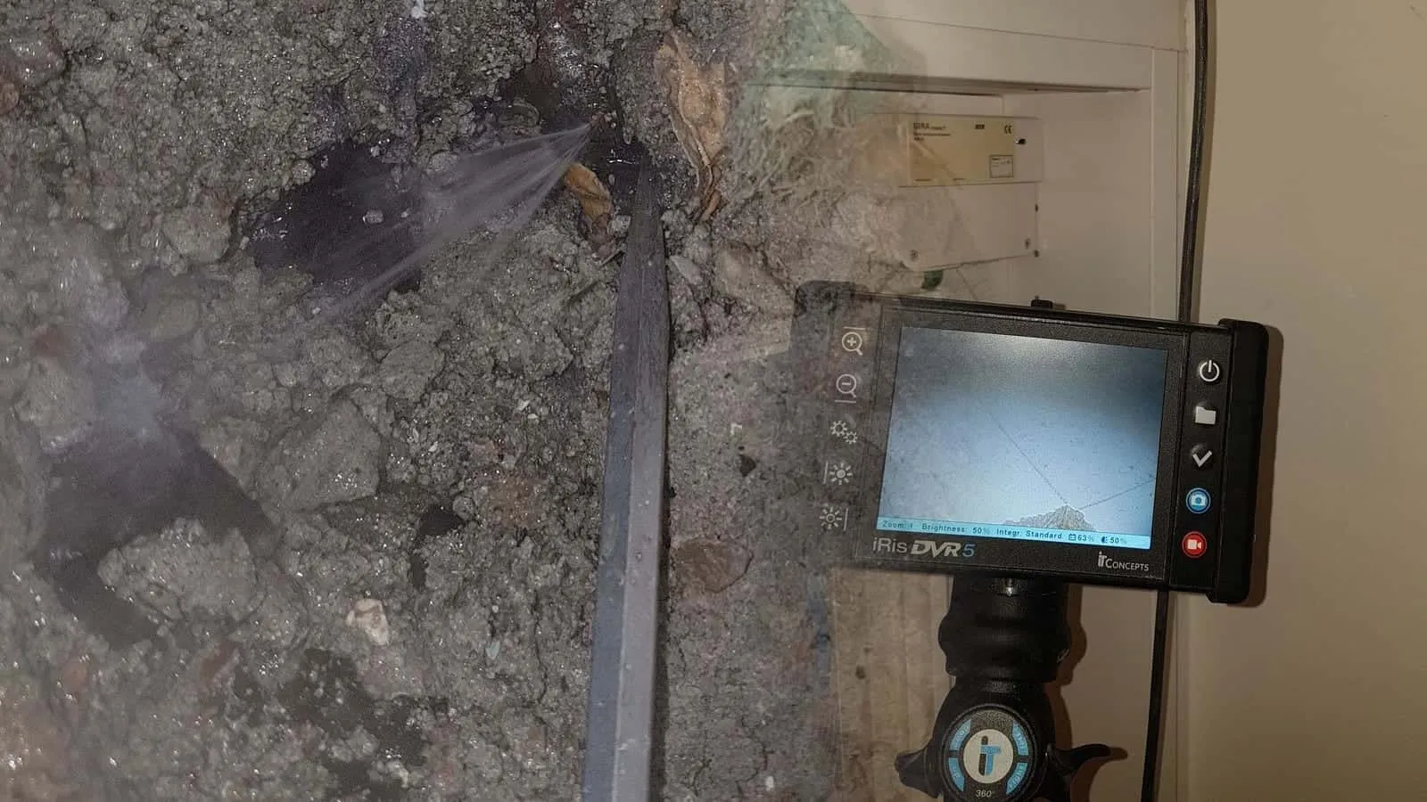 Endoskop mit Monitor vor einem offenen Verteiler mit Klemmen und Kabeln