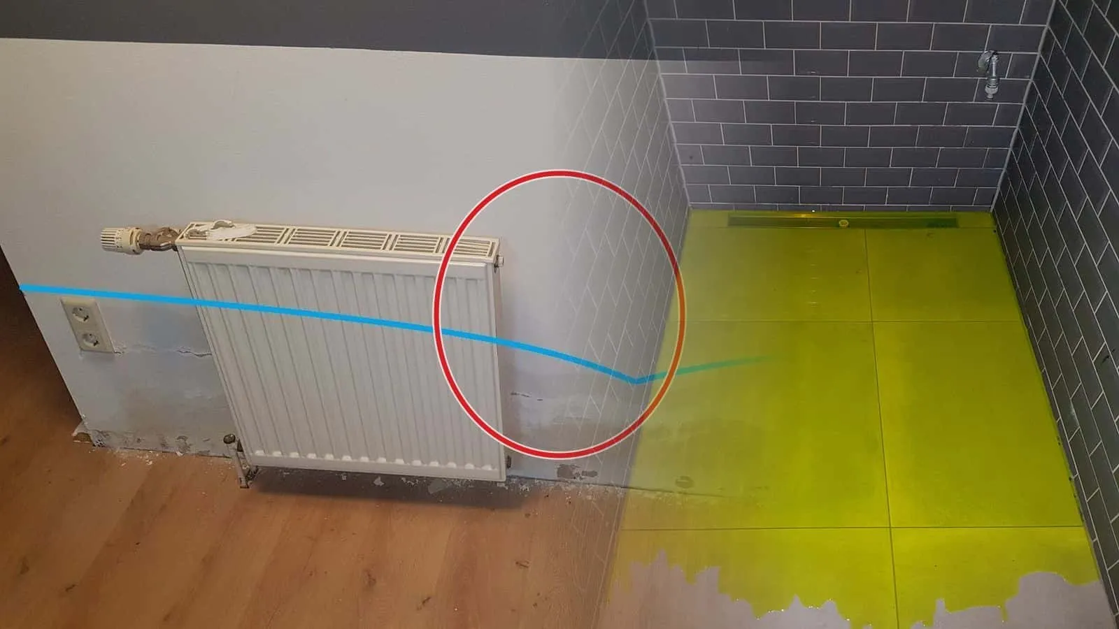 Duschboden mit gelb eingefärbtem Wasser für die Dichtheitsprüfung, graue Metrofliesen, Duschrinne an der Wand