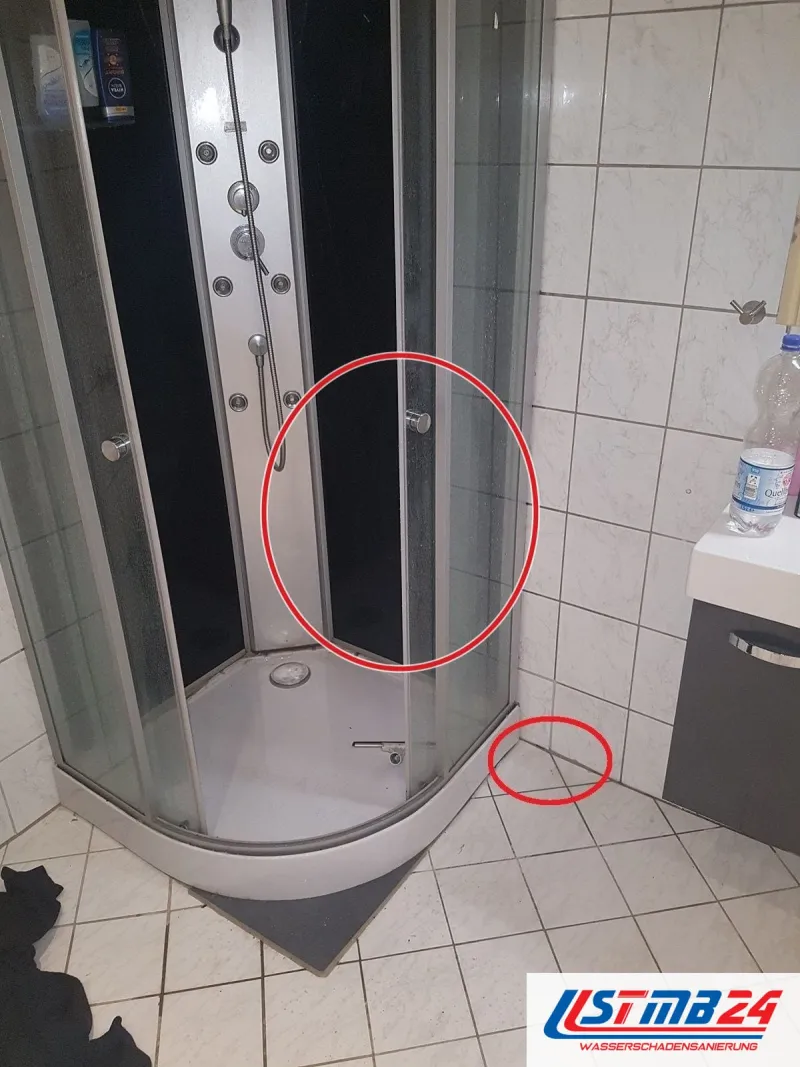 Eckdusche mit Glastüren, ein roter Kreis an der Bodenfuge neben der Duschtasse, ein roter Kreis markiert die Stelle
