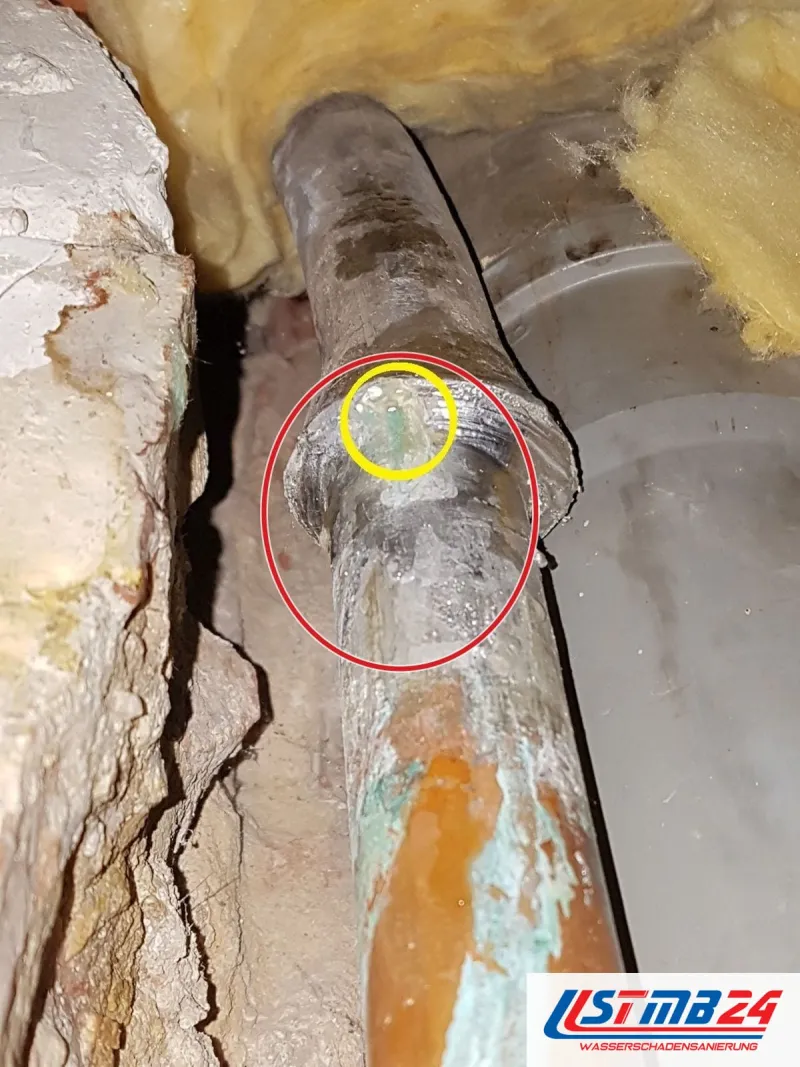 Kupferrohr mit Grünspan, gelb umkreist die undichte Verbindung, ein roter Kreis markiert die Stelle