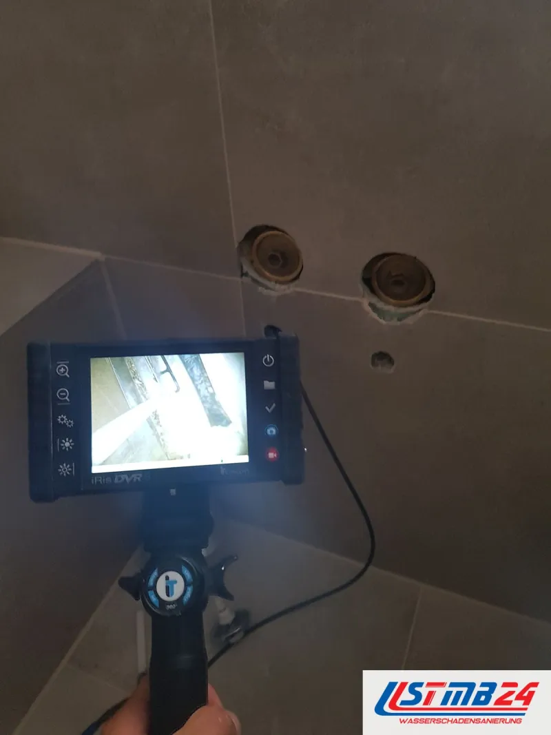 Endoskop mit Monitor vor einer gefliesten Wand, die Sonde steckt in einem der beiden geöffneten Anschlüsse