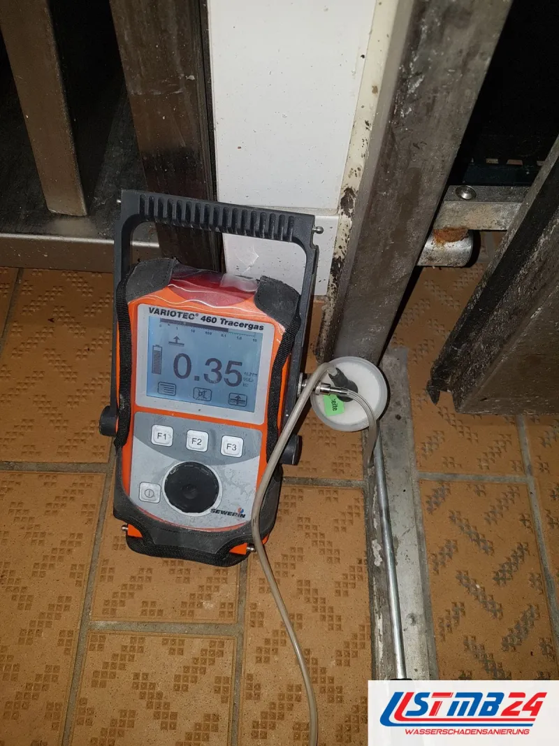 Gasspürgerät Variotec 460 Tracergas mit Anzeige 0,35 auf gemusterten Bodenfliesen, die Bodensonde steht vor einer Türzarge