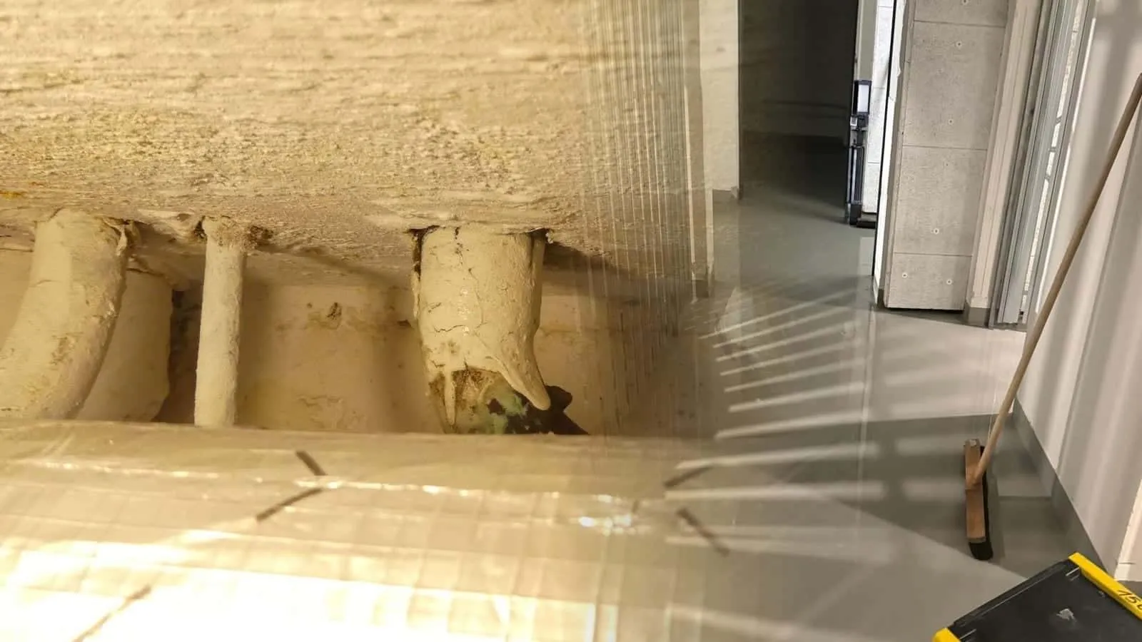 Rohbauflur mit nassem Estrich und gelbem Trocknungsgerät