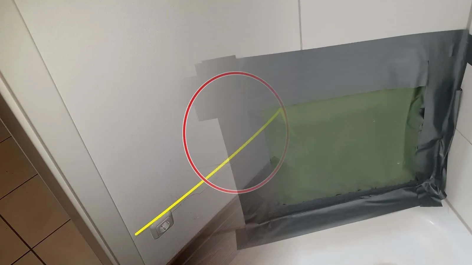 Geöffnete Fliesenwand, die Öffnung mit Folie und Klebeband verschlossen