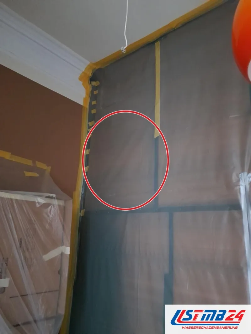 Folienwand mit gelbem Klebeband an der Decke, ein roter Kreis markiert die Stelle