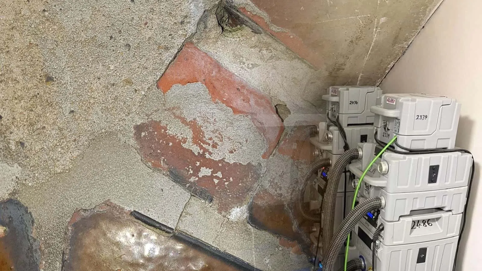 Gestapelte Trocknungsgeräte unter einer Treppe mit Saugschläuchen