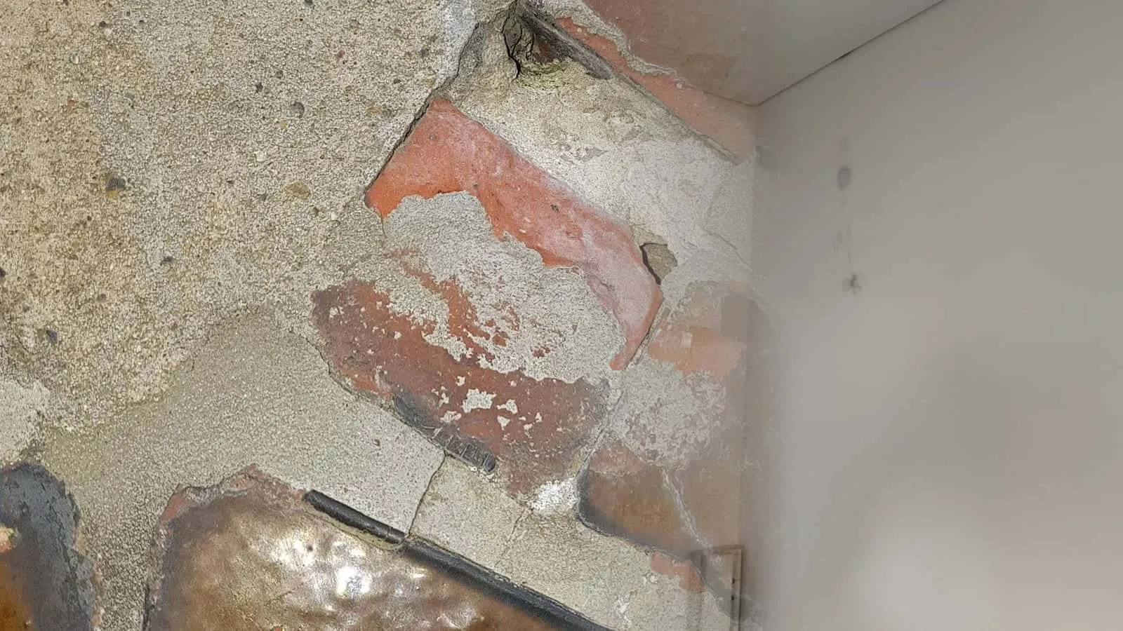 Helle Wand mit kleinen dunklen Punkten neben einer Tür