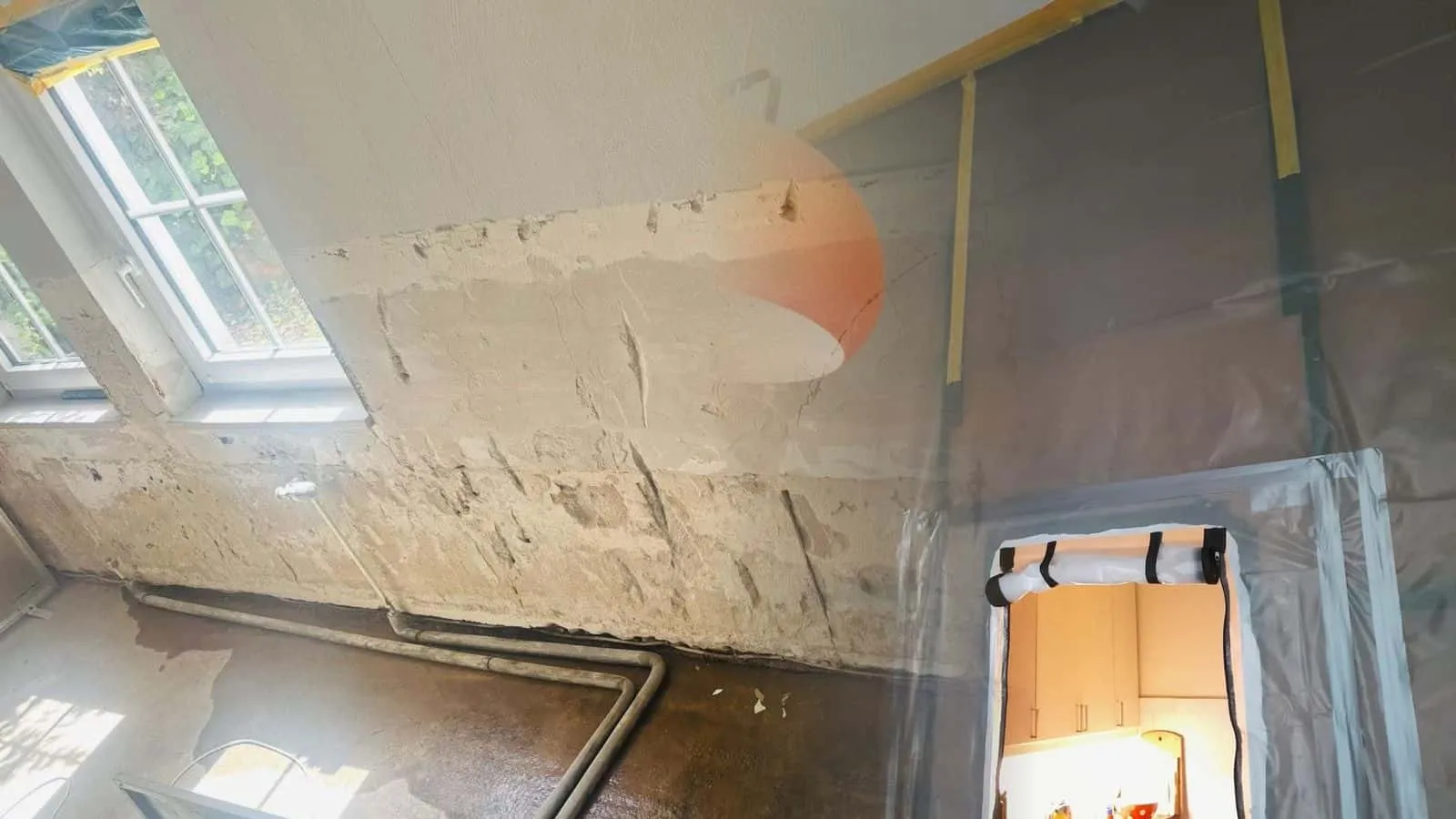 Staubschutzwand aus Folie mit Reißverschlusstür vor einer Küche