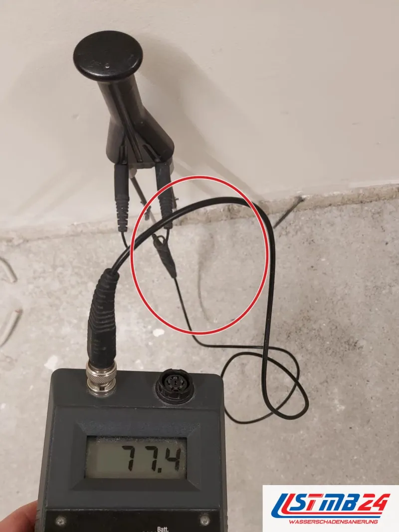 Messgerät mit Anzeige 77,4, Elektrode an der Wand, ein roter Kreis markiert die Stelle