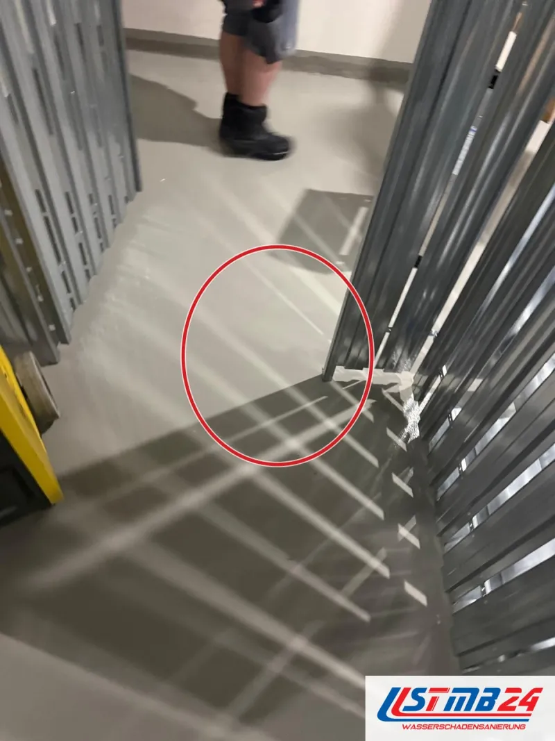 Neues Ständerwerk aus Metallprofilen in einem langen Raum, ein roter Kreis markiert die Stelle