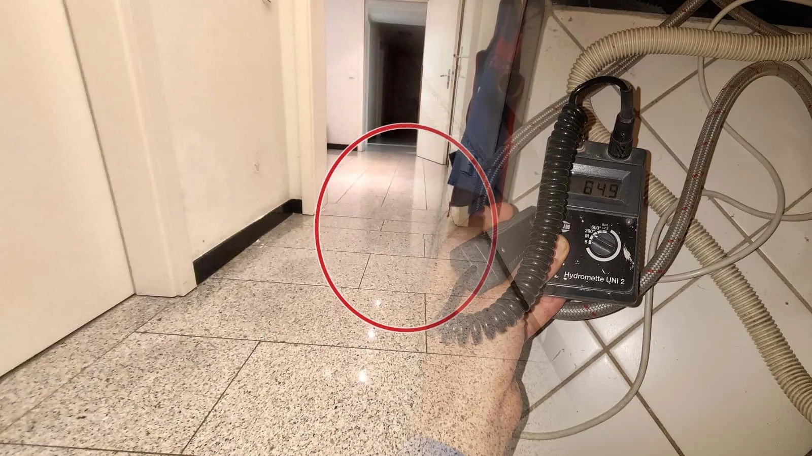 Messgerät mit Anzeige 64,9 über Schläuchen, die am Boden liegen