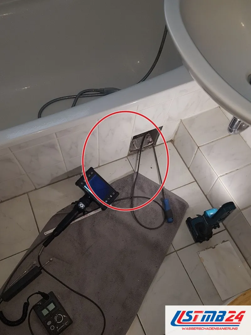 Endoskop vor der Wanne mit Revisionsöffnung, ein roter Kreis markiert die Stelle