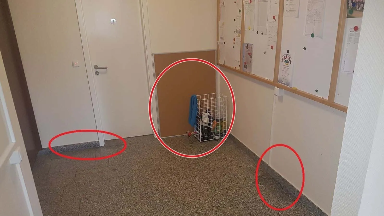 Flur mit Steinboden, am Wandfuß sind zwei Stellen rot umkreist
