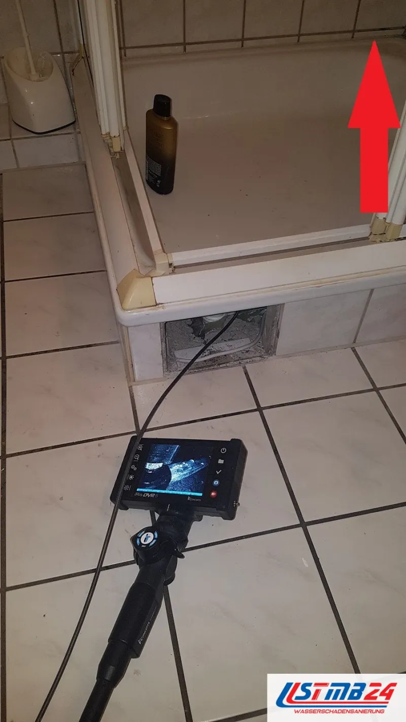 Endoskop mit Monitor auf dem Fliesenboden, die Sonde führt durch die Revisionsöffnung unter die Duschtasse