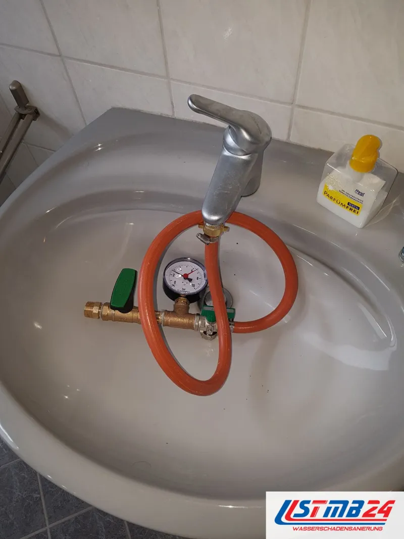 Waschbecken mit orangem Schlauch und Prüfgerät