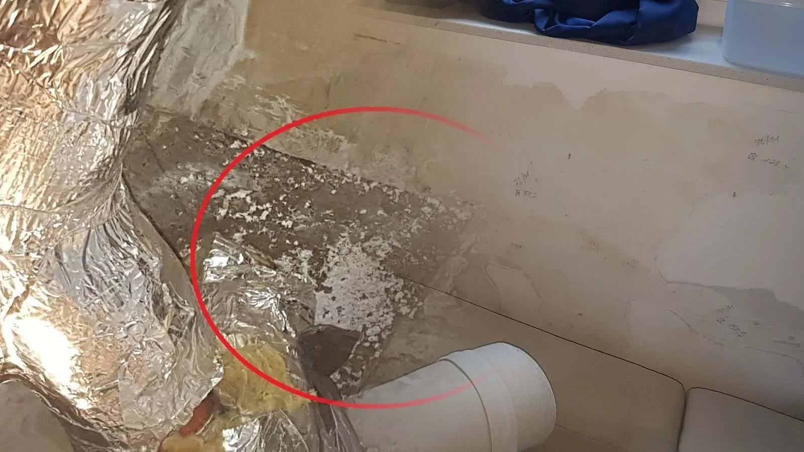 Kellerfenster über einer Wand mit Wasserrändern