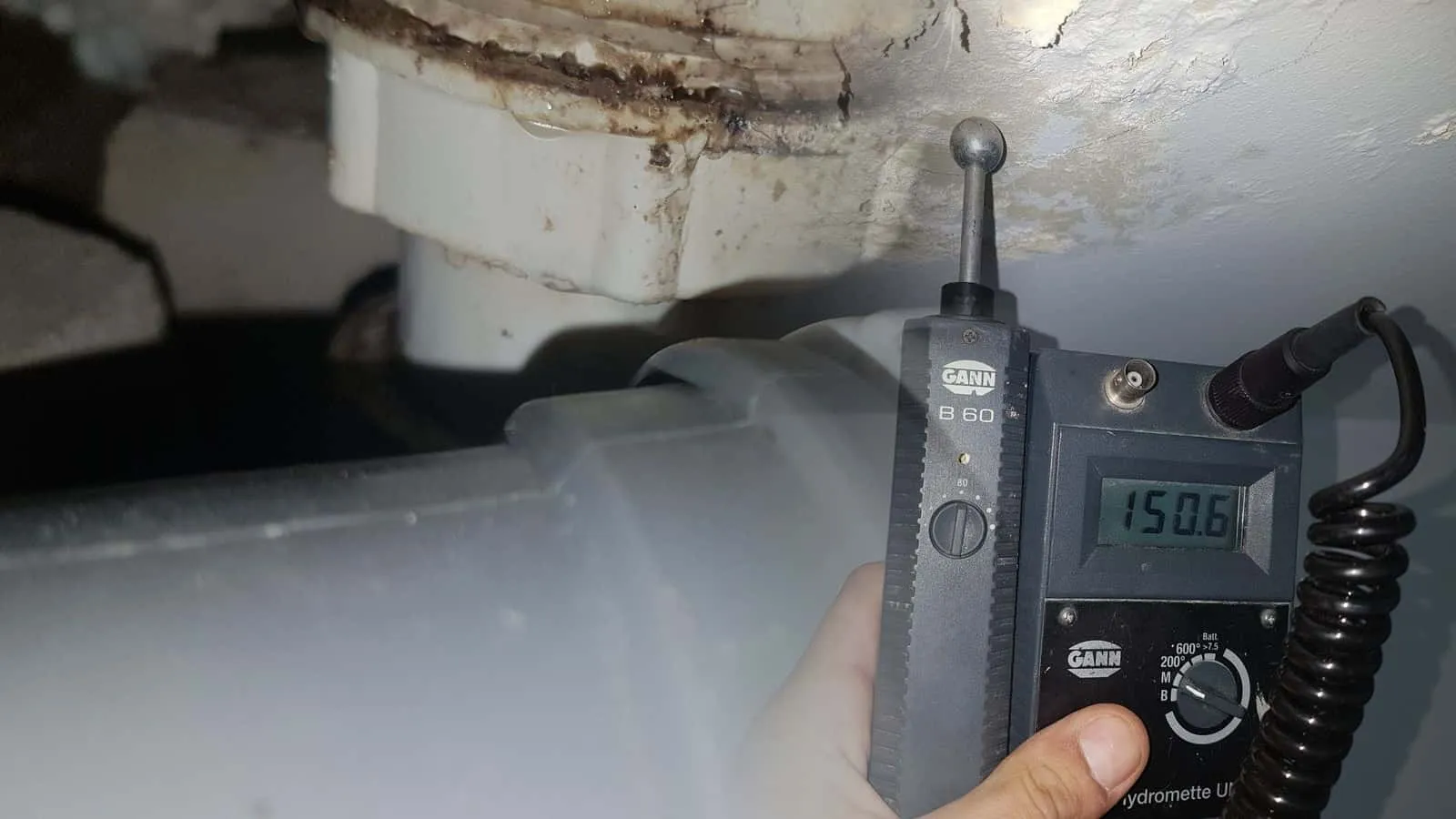 Kugelsonde an einer Zimmerdecke mit abblätternder Farbe, die Hydromette in der Hand zeigt 150,6